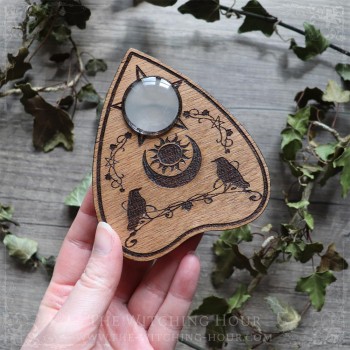 Ouija planchette with crows and a moon crescent