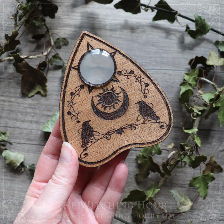 Ouija planchette with crows and a moon crescent