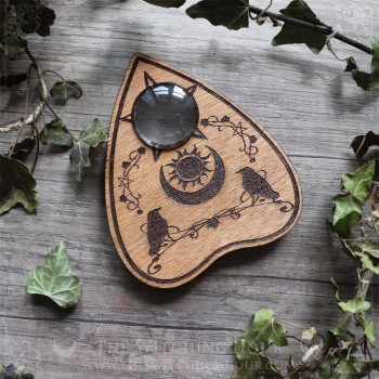 Ouija planchette with crows and a moon crescent